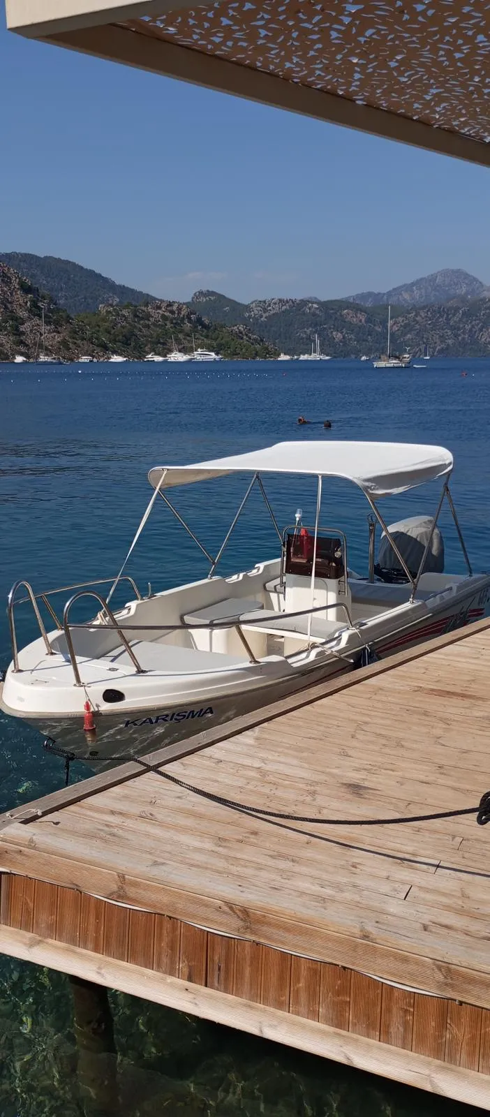 İskeleye bağlı botta metal taşıyıcıların üzerindeki açık renk bimini tente