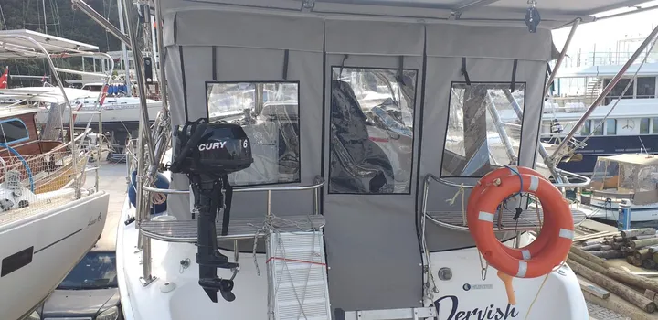 Teknenin kıçında fermuarlı giriş bölümü ve ayrı şeffaf panelleri görülen kumaş kapama