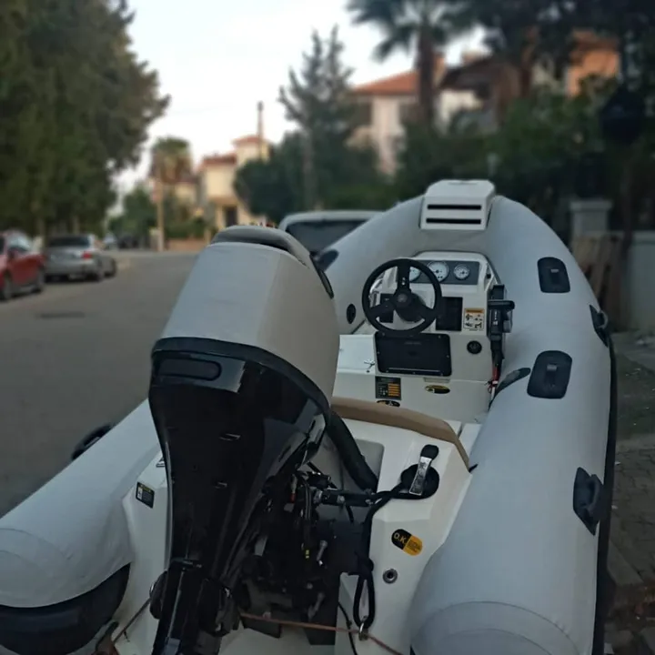 Konsollu şişme botta motorun ve oturma bölümünün çevresine uyarlanan açık renk kumaş