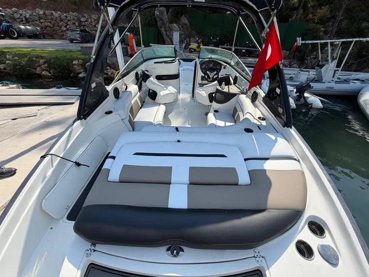 Motorlu teknenin kıç bölümünde koyu gri ve beyaz panellerle düzenlenen geniş minder