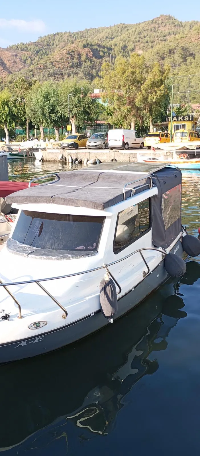 Marinadaki motorlu teknenin kıç oturma alanını çevreleyen şeffaf panelli kapama